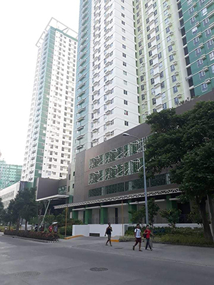people passing by avida towers riala condominium